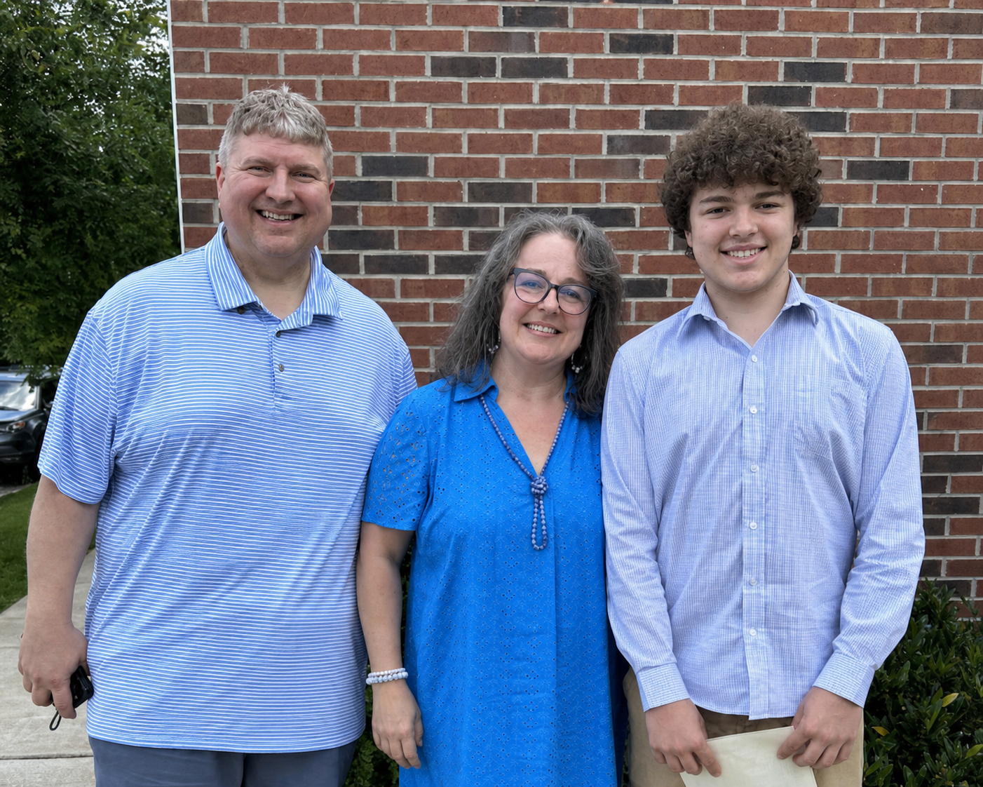 Three members of the Heglar family smiling together outdoors